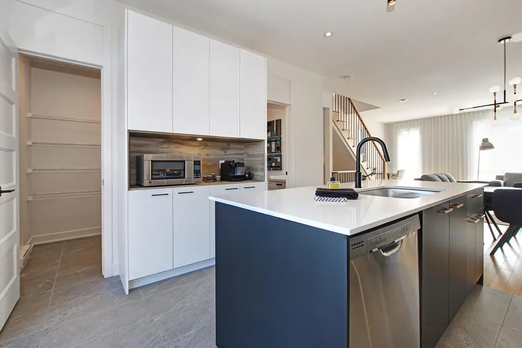 Cuisine moderne avec îlot central et aire ouverte dans une maison de ville à Laval