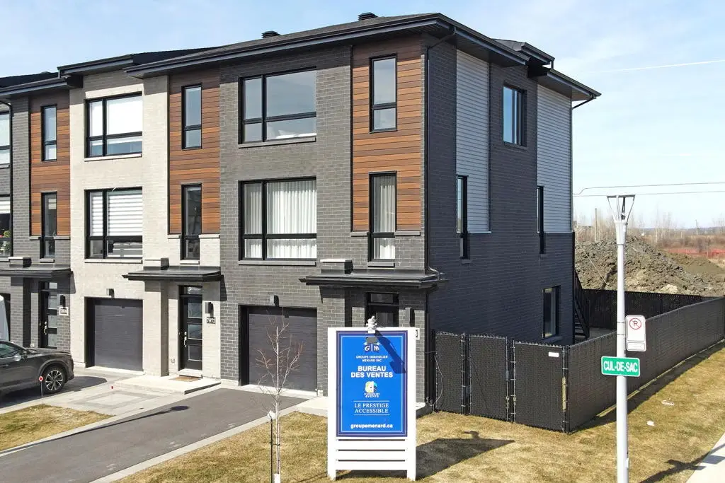 Rangée de maisons de ville modernes en brique et bois avec bureau des ventes, projet de maisons de ville neuves à Laval