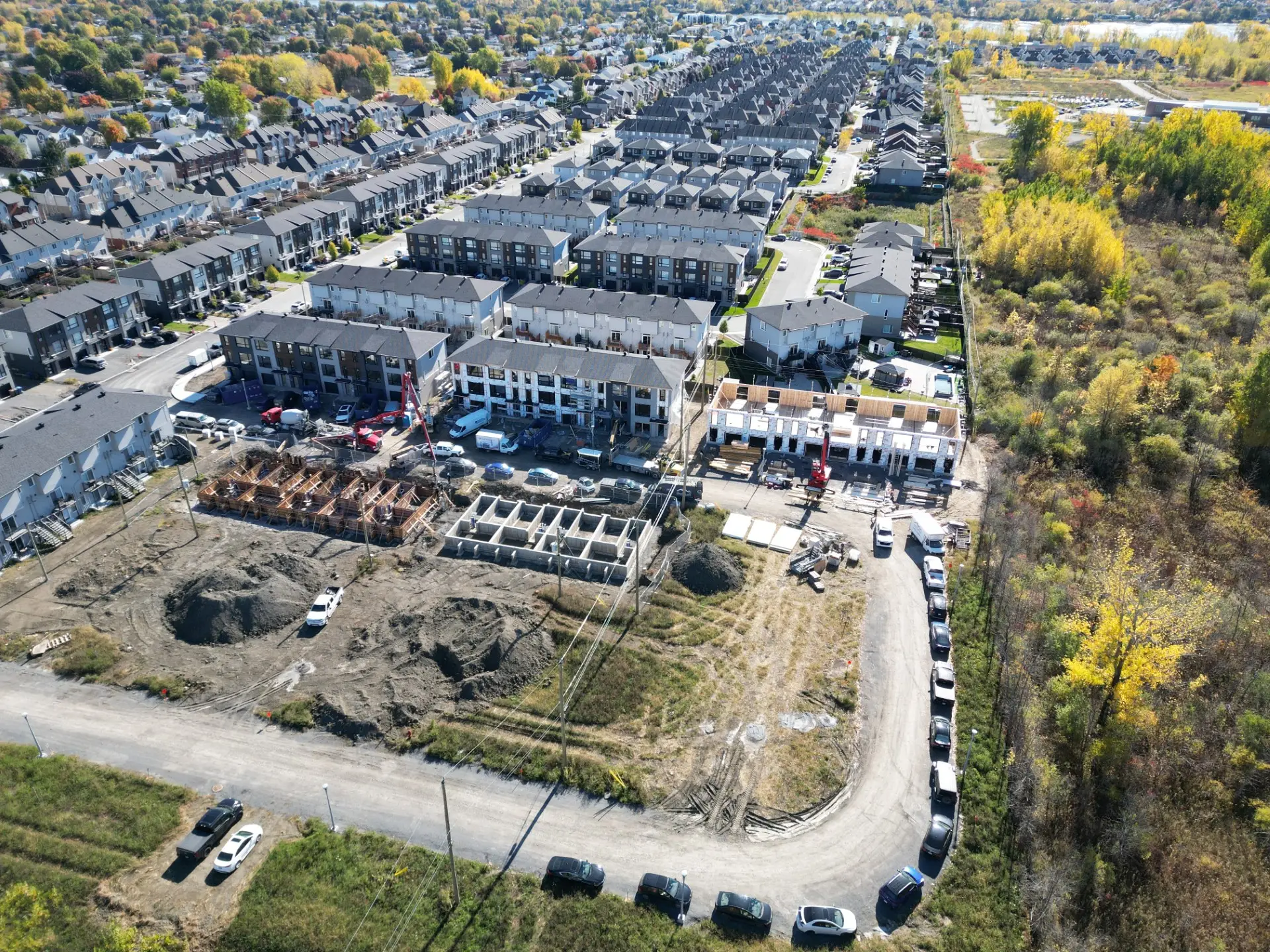 Vue aérienne d’un projet de maisons de ville neuves à Laval en construction, rangées modernes et chantier actif